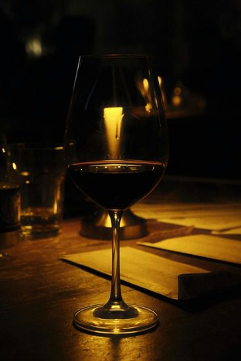 OLIVA — ποτήρι κόκκινο κρασί στο φως κεριού